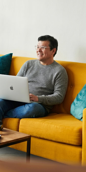 digital marketer casually working on a yellow couch